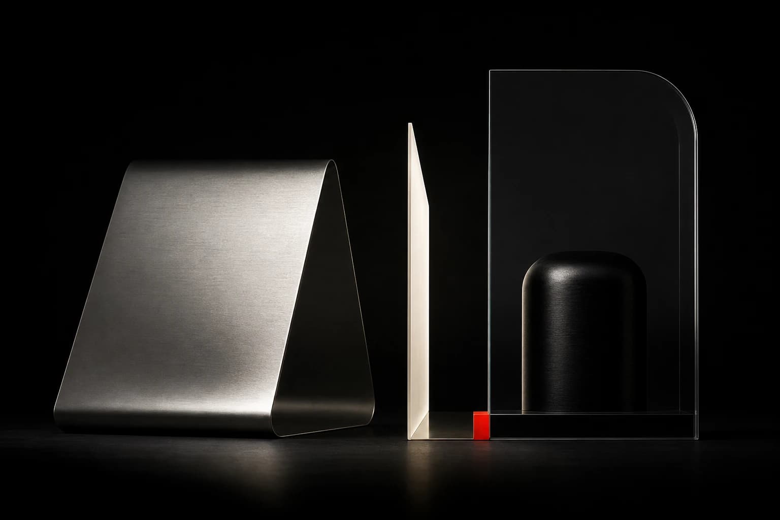 Three distinct precision forms in silver, ivory and black, with the third enclosed behind smoked glass and a small red hinge