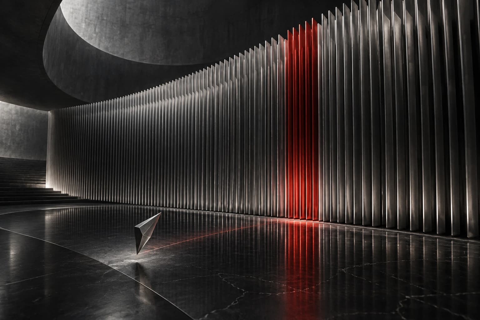 A large curved wall of silver fins contains one narrow red band, with a small silver shard in the foreground